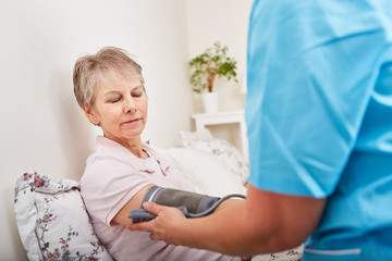 Blutdruck einer Seniorin wird kontrolliert