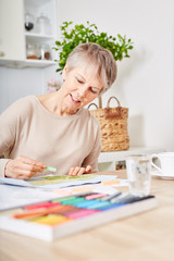 Alte Frau mit Demenz beim kreativen Malen