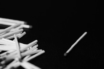 Scattered matches on dark background close up. Black and white