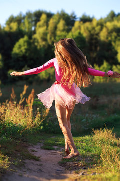  Beautiful teen girl  Is dancing outside at  summer sunset