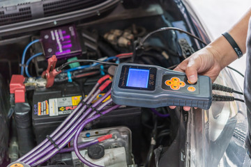 Checking a car battery for repair at car garage