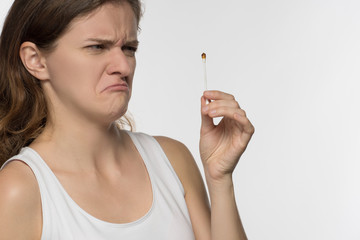 Young beautiful brunette girl cleans the ears with chopsticks with cotton wool and is surprised to...