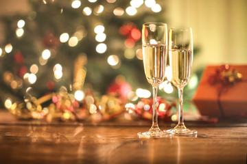 Two wine glasses in front of a christmas tree
