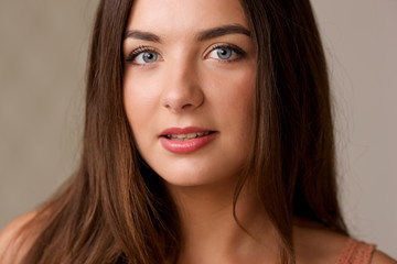 Naklejka premium Portrait of beautiful brunette young girl with long hair closeup.