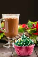 Green christmas cupcake with glass of cocoa