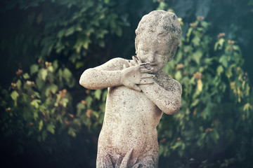 statue of scared little boy, sculpture of  frightened child in a garden