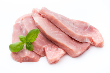 Fresh pork fillet with basil on a white background.