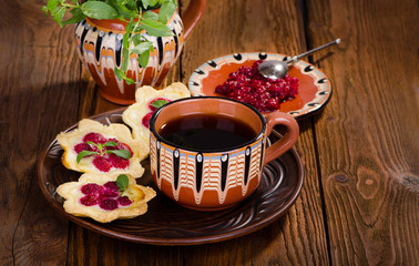 Raspberry dessert tarts with berries and mint tea, delicious breakfast