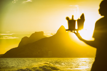 Defocused brazilian beach vendor carrying caipirinha cocktails at Arpoador with a sunset view of...