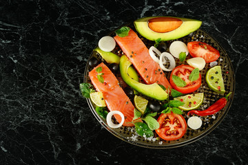 Fillet of red fish and spices on black background.