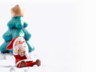 Cute happy Santa Claus dolls and Christmas props decorations on christmas snow field background with copy space.Merry Christmas and happy new year concept.