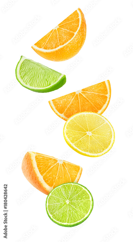 Fototapete Isolated falling citrus pieces. Slices of orange, lemon and lime floating in the air isolated on white background with clipping path