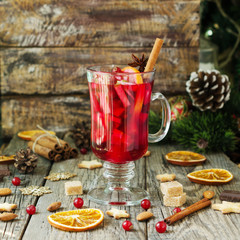 glass of hot mulled wine for the new year with ingredients for cooking, nuts and Christmas...