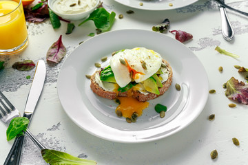 Sandwich, toast with avocado, soft cheese and poached egg on white background