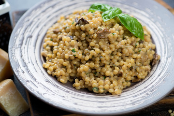 Close-up of pasta with porcini mushrooms and parmesan cheese served on a plate, selective focus