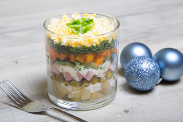 Traditional Russian salad Olivier with sausage in a glass. Selective focus, close - up.