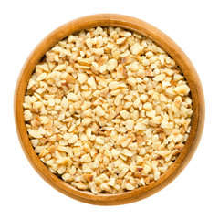 Hazelnut kernels, roughly chopped, in wooden bowl. Edible dried shelled seeds of Corylus avellana,...