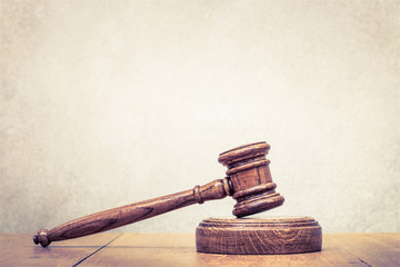 Retro auction or judge wooden gavel on table. Vintage old style filtered photo