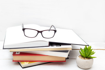 Stack of books and glasses on a white background