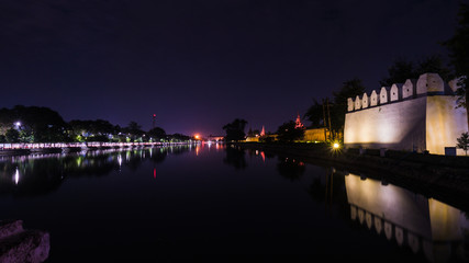 Fototapeta na wymiar The panoramic scenery of the fort and the reflection in the moat at Mandalay Palace. Night Landscape of Fort at Mandalay Palace. Long exposure night image