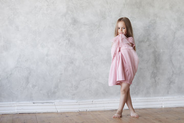 Full length portrait of beautiful barefooted timid European little girl with long loose hair...