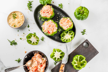 Autumn recipes. Home stuffed bell pepper with minced meat, carrots, tomatoes, herbs and cheese. Cooking process. On a white marble table. Top view. Copy space
