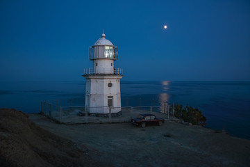 Night sea landscape - lighthouse in the light of the moon