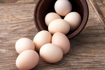 chicken eggs in a bowl on wooden background