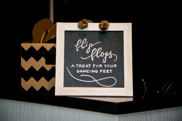 Blackboard advertising for flip flops at a wedding