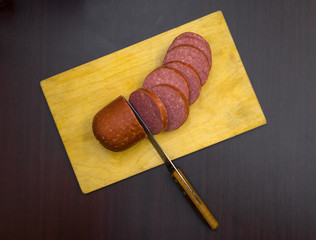Fresh sausage meat sliced on cutting Board with knife