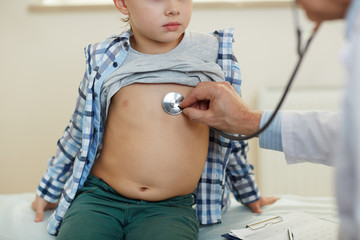 Check-up of little boy breath and heart-beat