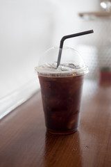 Iced black coffee on wooden table
