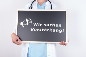 Arzt mit Schild wir suchen Verstärkung