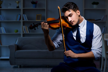 Young musician man practicing playing violin at home