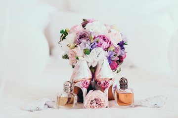 Beautiful light shoes fiancees cost near a varicoloured bouquet and accessories on a white background