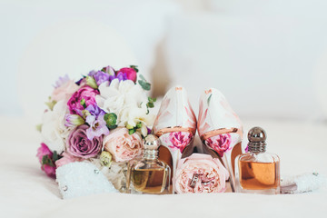 Beautiful light shoes fiancees cost near a varicoloured bouquet and accessories on a white background