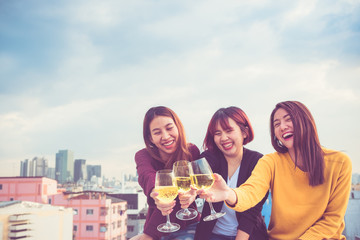 Happy group of asia girl friends enjoy laughing and cheerful sparkling wine glass at rooftop party,Holiday celebration festive,teeage lifestyle,freedom and fun.
