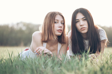 Two young women rest on the grass. Best friends