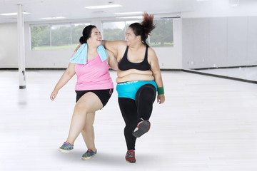 Obraz premium Two women laughing in the fitness center