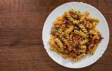 fusilli pasta with mushroom and cream sauce on a wooden background. with copy space. top view