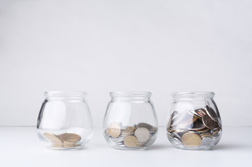 Increasing quantity of coins in glass jar