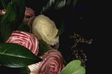 Bouquet of cupcake and green leaves in a black flowerpot. Dark background. A gift to the girl.