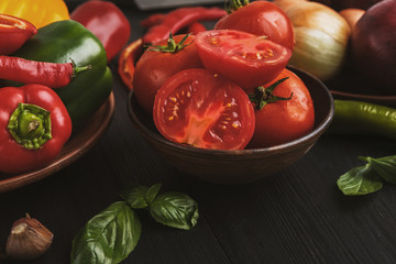 Fresh tomato, pepper in dark bowl