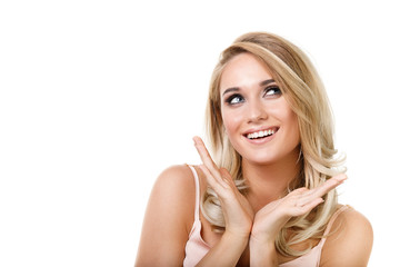 Fototapeta premium Portrait of a young beautiful blonde girl on a white background. Model looks dreamily away