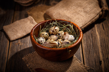 Quail eggs in wooden bowl