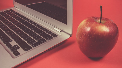 Modern laptop computer on red background .