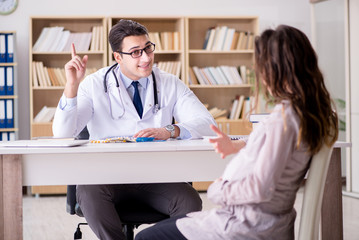 Fototapeta premium Pregnant woman visiting doctor for consultation