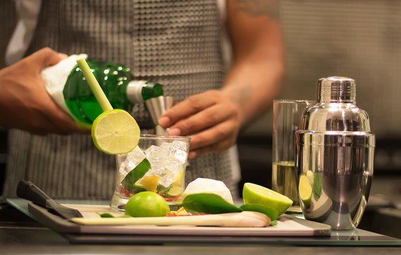 A Professional Bartender Is Making Cocktails For Customers. Meticulously