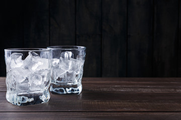 Glasses with ice cubes on dark background