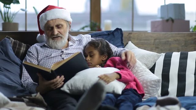 Grandpa reading bedtime story to sleepy child
